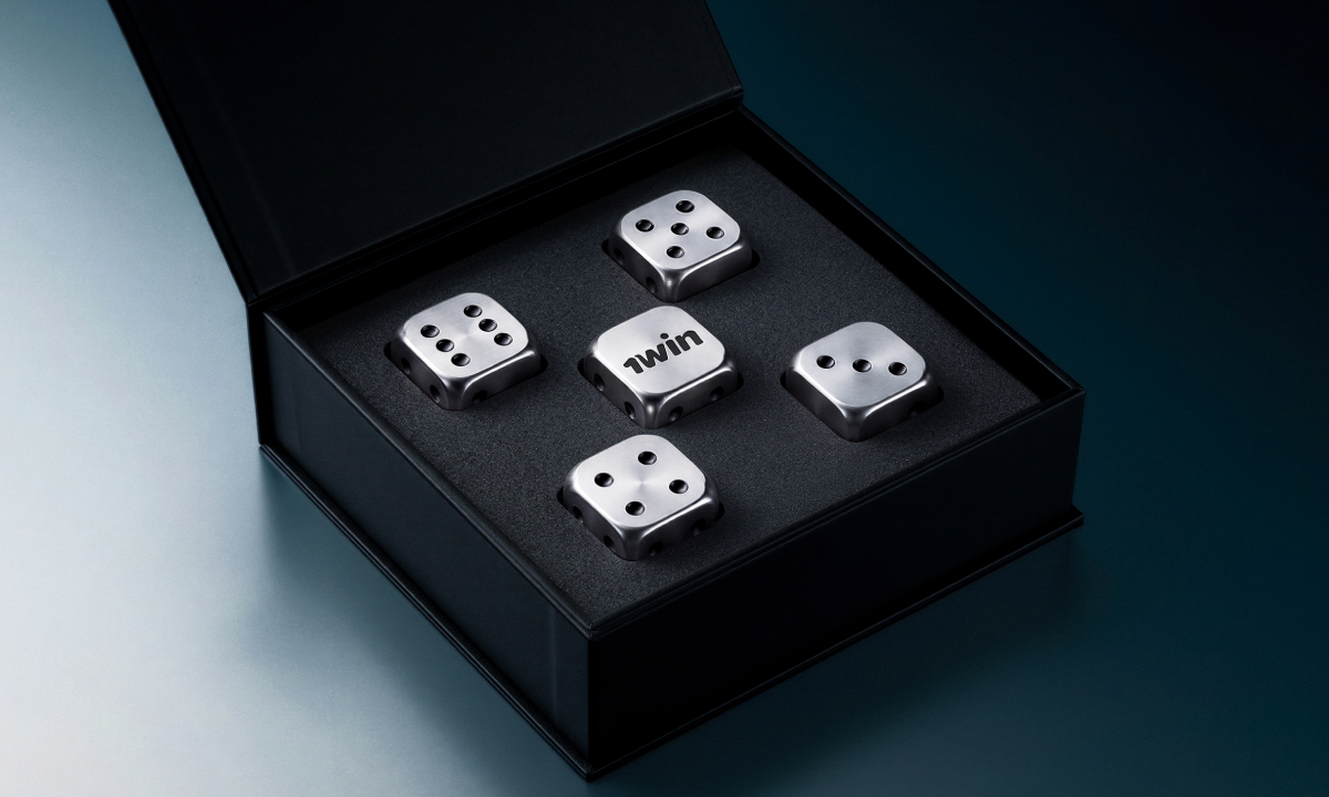 A black box contains five metallic dice, one labeled "1win," arranged neatly on a dark background, highlighting their sleek design.